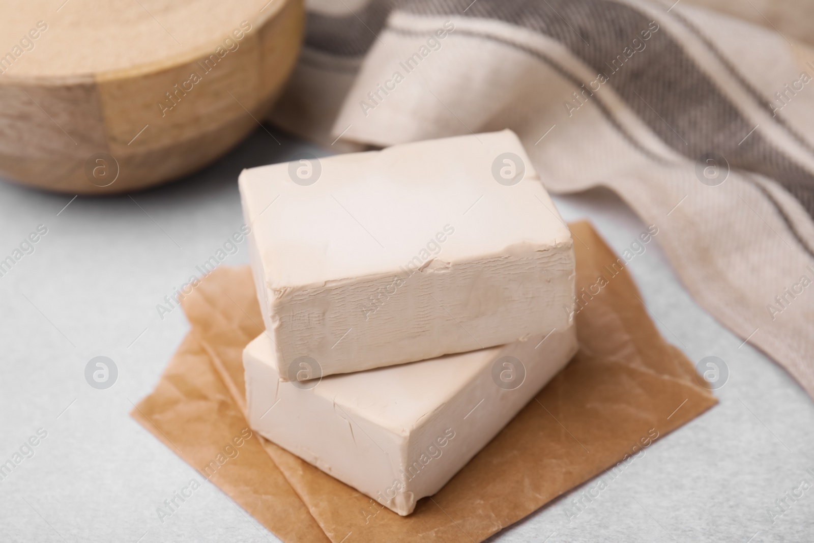 Photo of Blocks of compressed yeast on light gray table, closeup