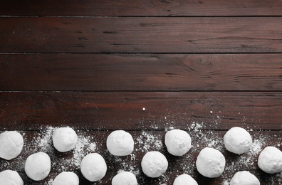 Frame of snowballs on wooden background, flat lay. Space for text