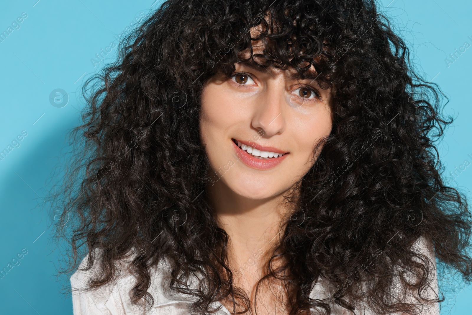 Photo of Portrait of beautiful young woman in sunlight on light blue background