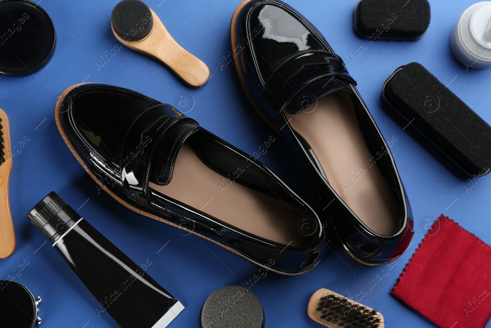 Photo of Shoe care accessories and footwear on blue background, above view