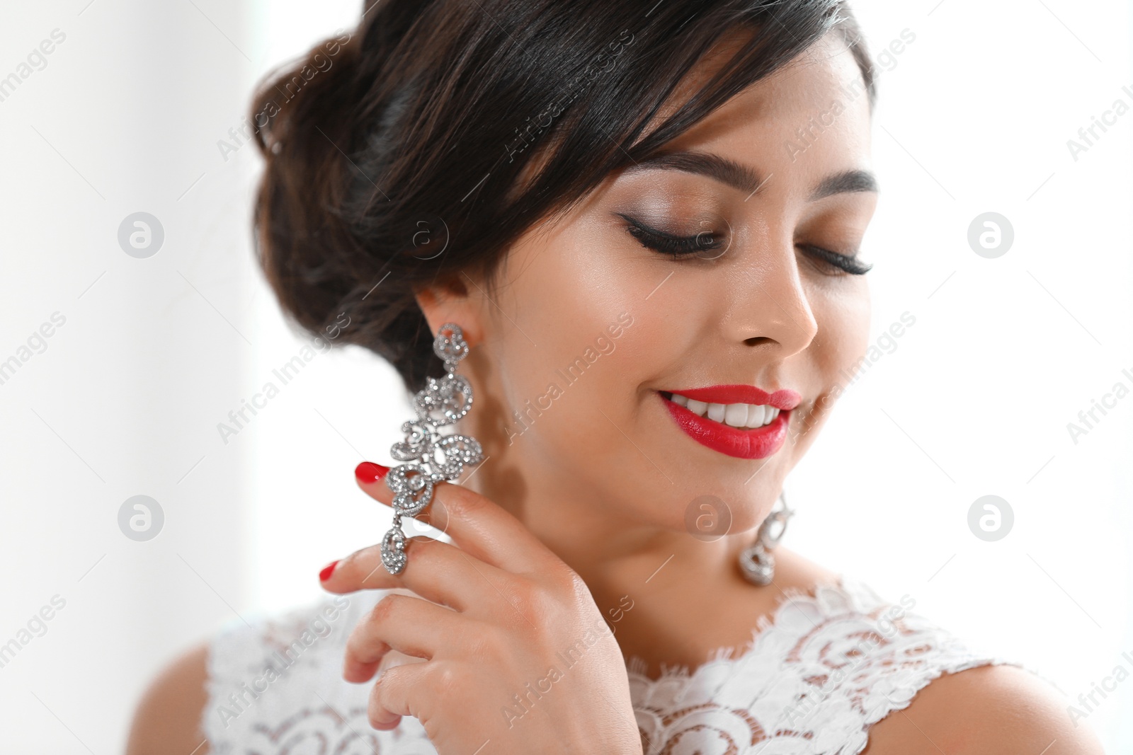 Photo of Beautiful young woman with elegant jewelry on light background