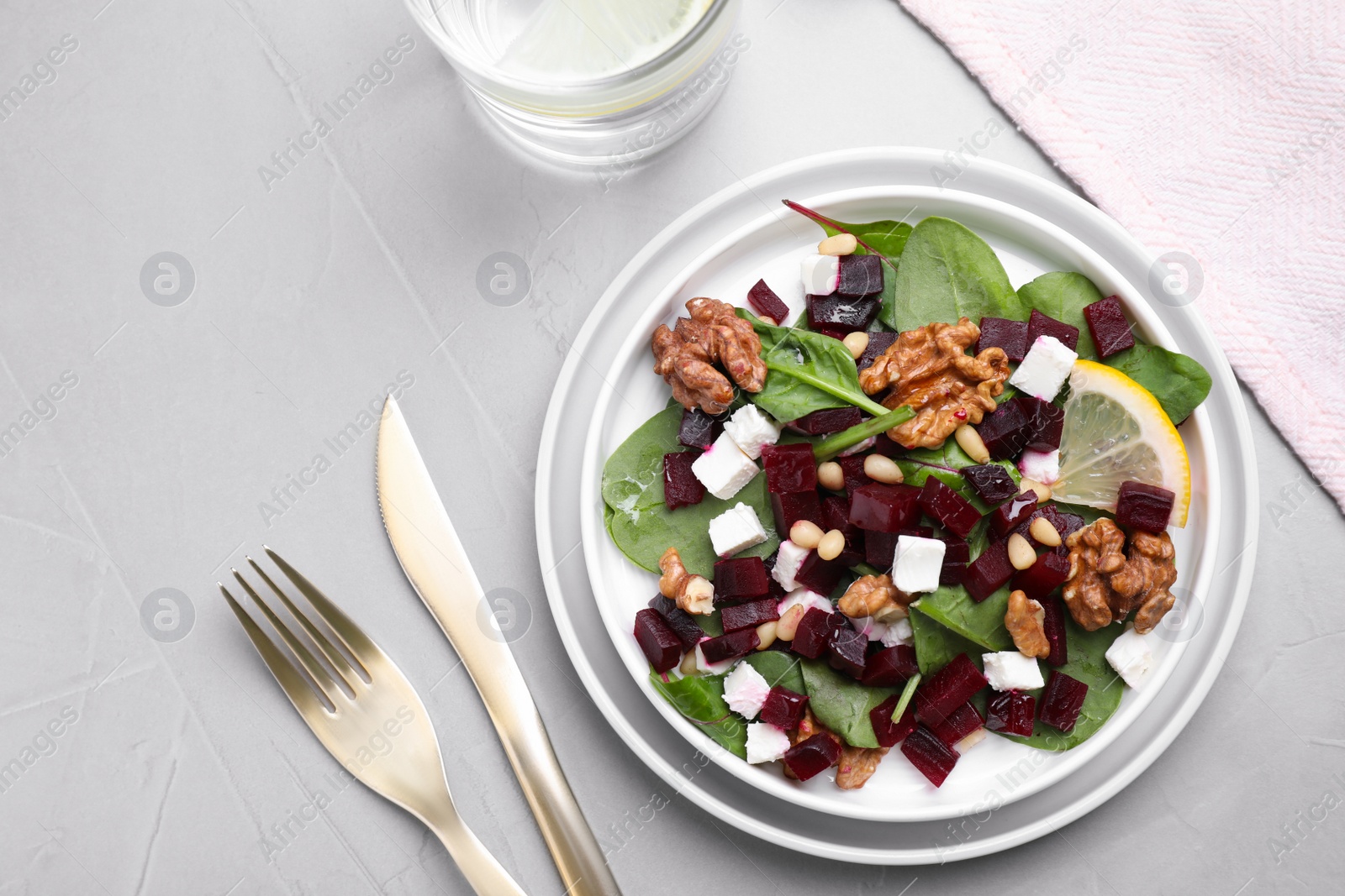 Photo of Delicious beet salad served on grey table, flat lay