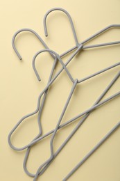 Photo of Hangers on pale yellow background, flat lay