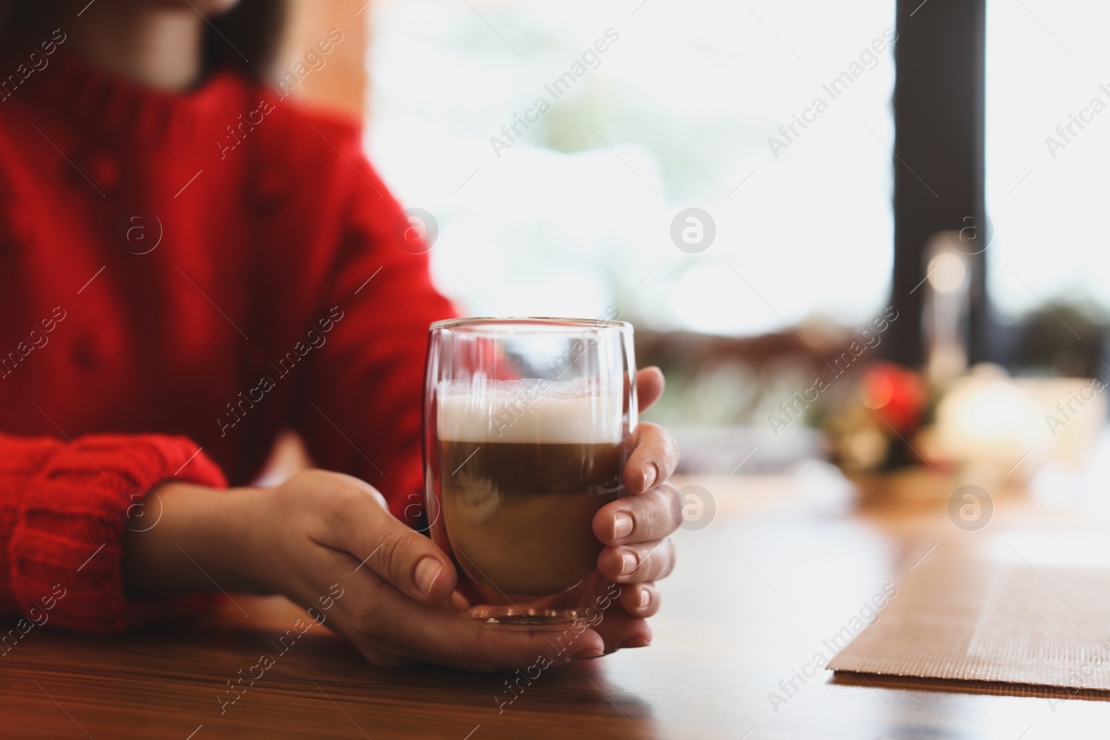 Photo of Woman with fresh morning coffee at table in cafe, closeup