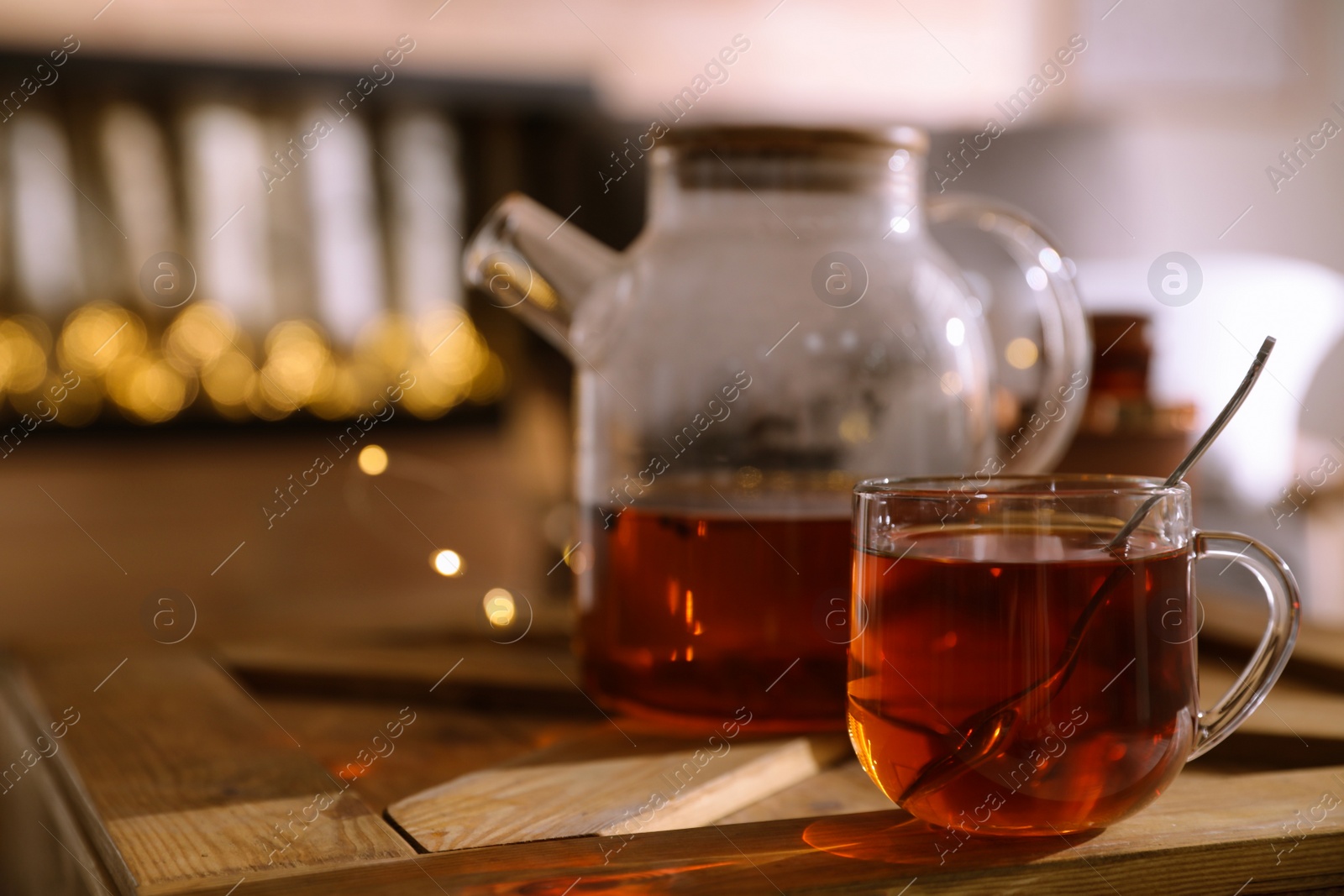 Photo of Teapot and cup with hot tea on table indoors, space for text