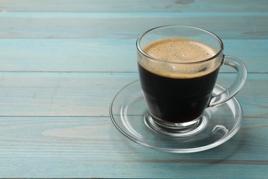 Cup of aromatic coffee on light blue wooden table, closeup. Space for text