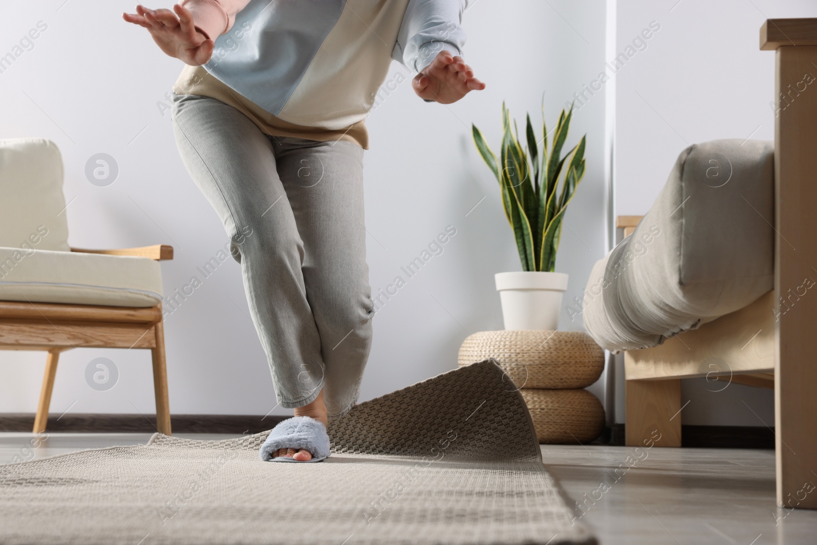 Photo of Woman tripping over carpet at home, closeup