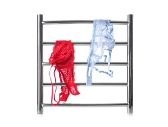 Photo of Modern heated towel rail with underwear isolated on white