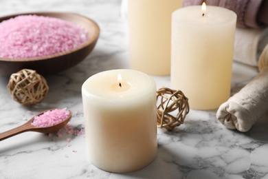 Photo of Aromatic candles and pink sea salt on white marble table