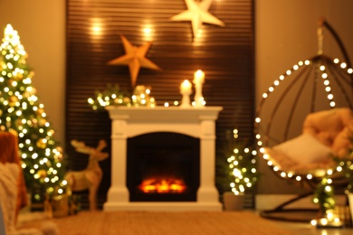 Photo of Blurred view of beautiful living room interior with burning fireplace. Christmas celebration