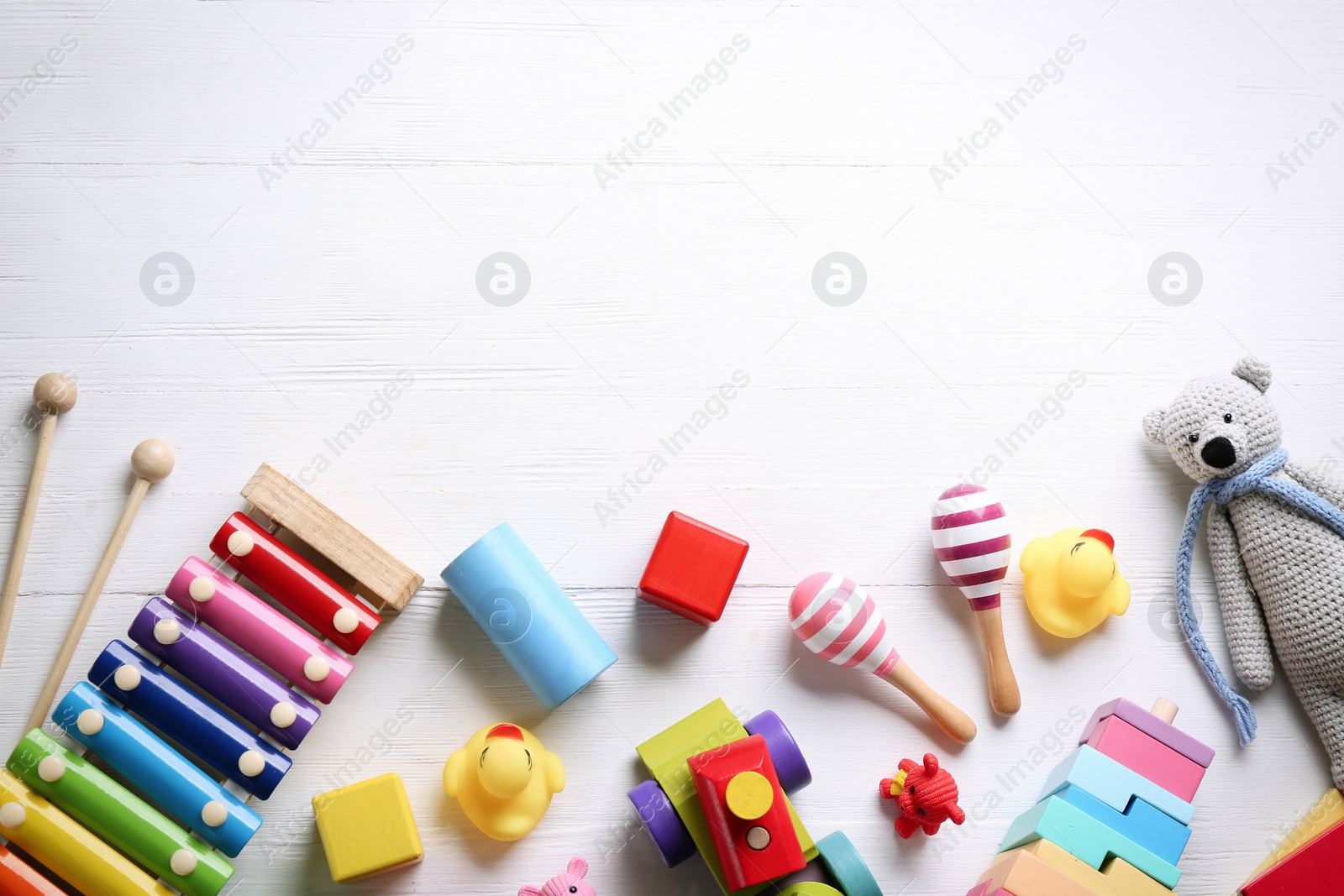 Photo of Different toys on white wooden background, flat lay. Space for text