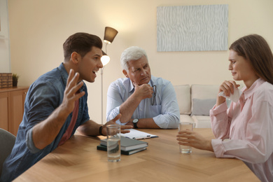 Professional psychotherapist working with emotional couple in office