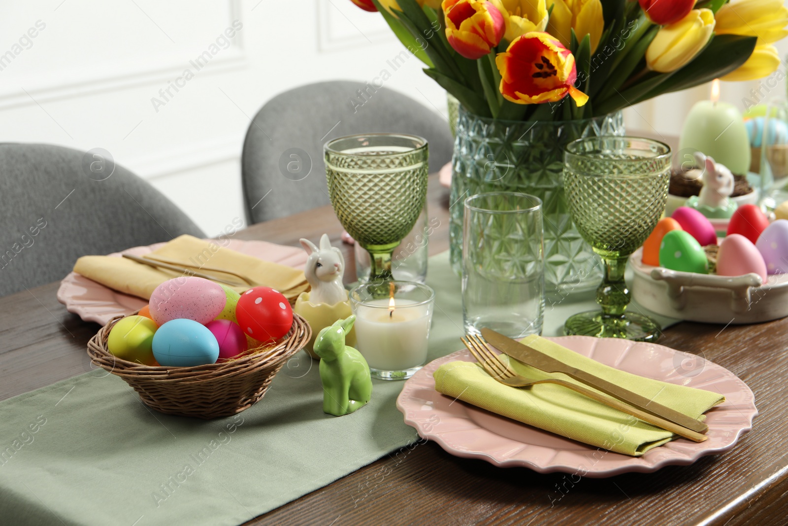 Photo of Easter celebration. Festive table setting with beautiful flowers and painted eggs