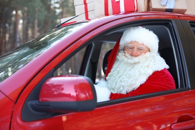 Authentic Santa Claus in red car, view from outside