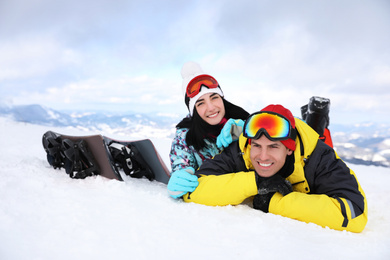 Lovely couple lying on snowy hill. Winter vacation
