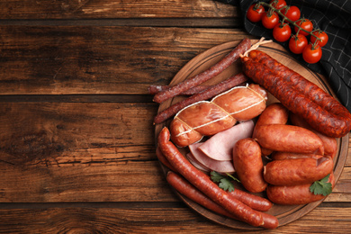 Photo of Different tasty sausages on wooden table, top view. Space for text
