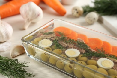 Photo of Delicious aspic with meat in glass dish on white table, closeup