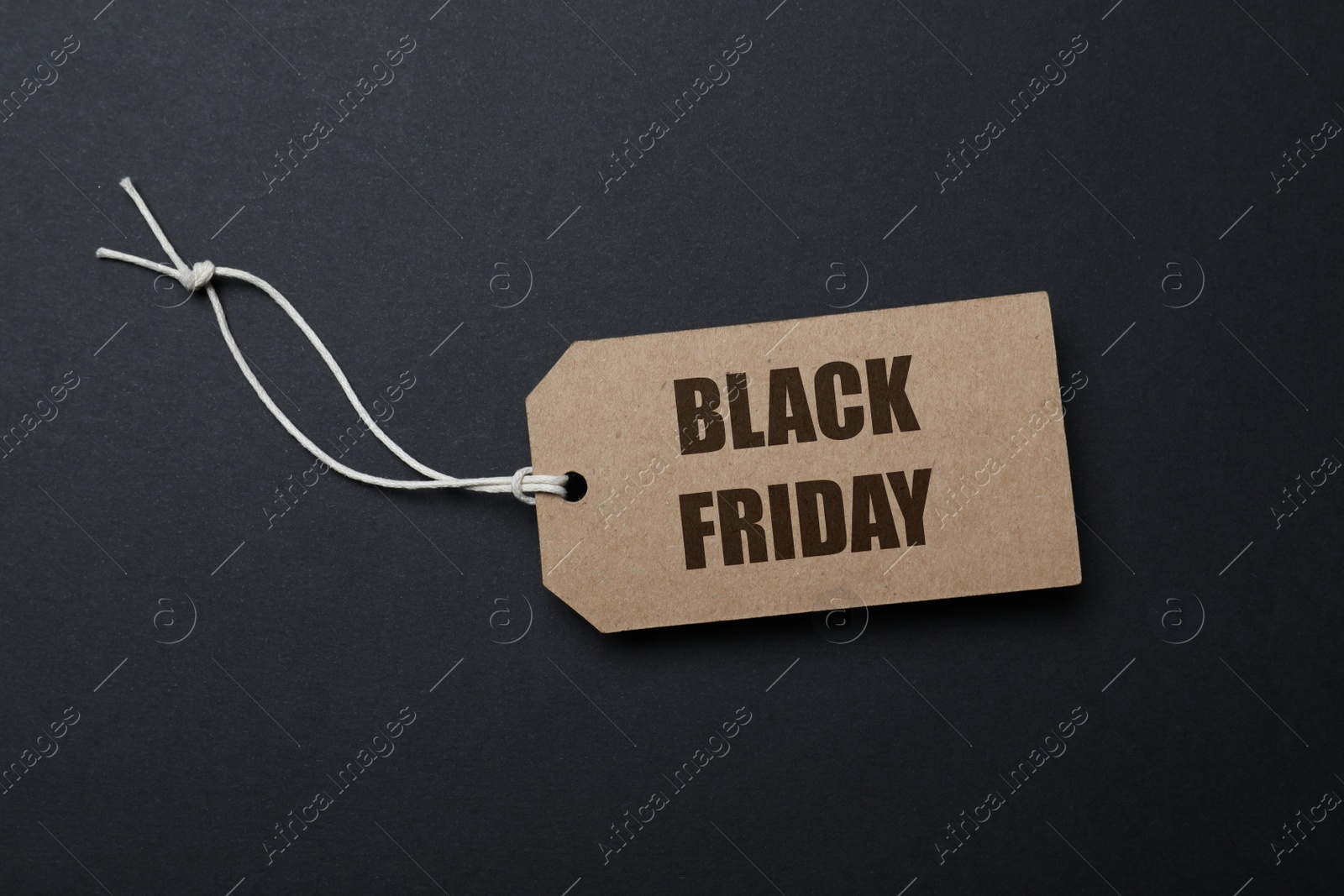 Photo of Tag with words Black Friday on dark background, top view