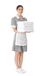 Photo of Young chambermaid holding stack of fresh towels on white background