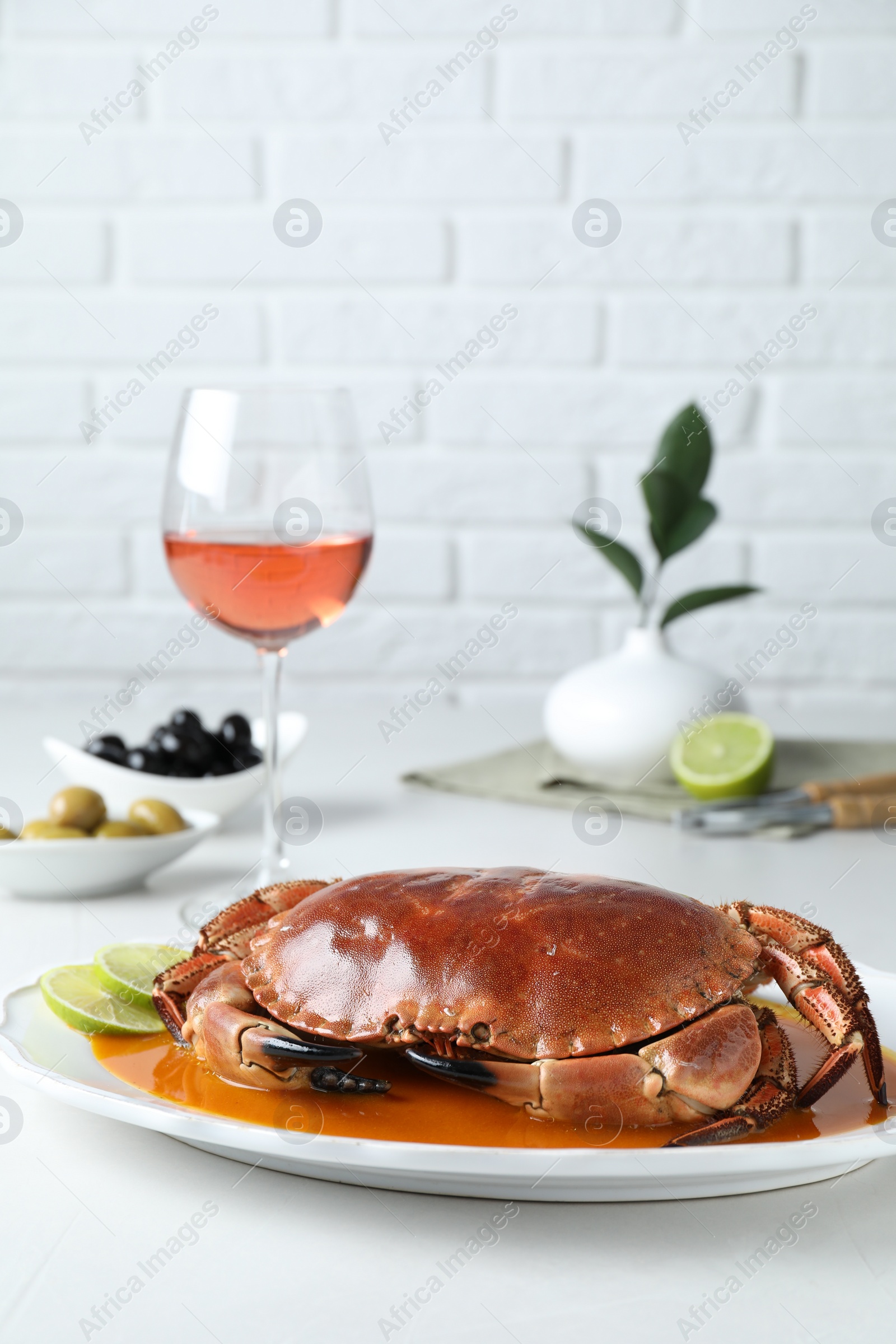 Photo of Delicious crab with sauce and lime served on white table