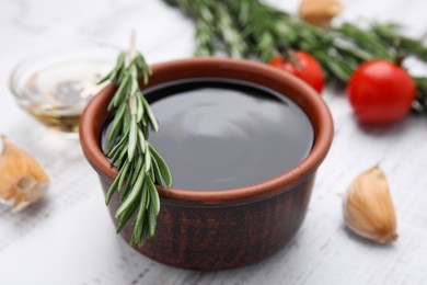 Organic balsamic vinegar and cooking ingredients on white wooden table, closeup