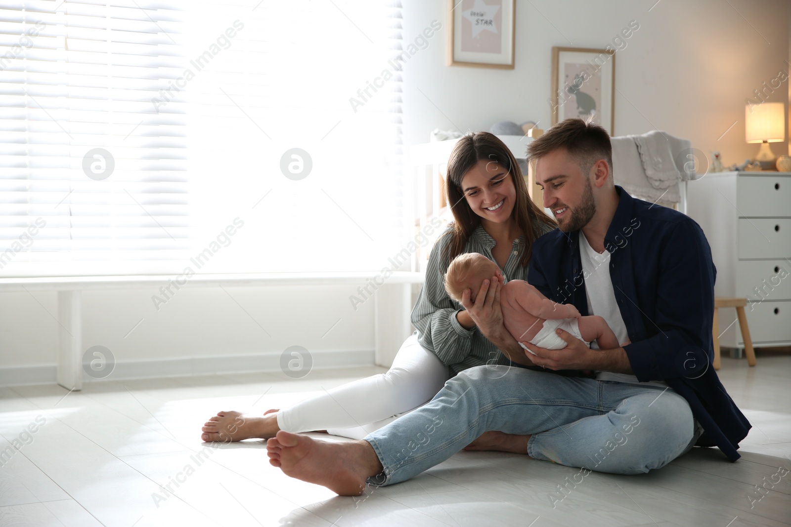 Photo of Happy couple with their newborn baby at home. Space for text