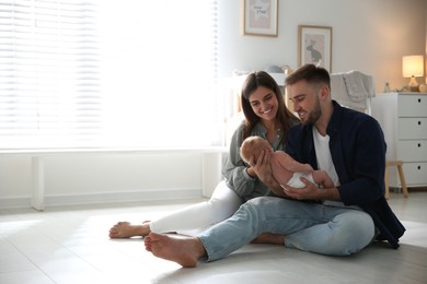 Happy couple with their newborn baby at home. Space for text