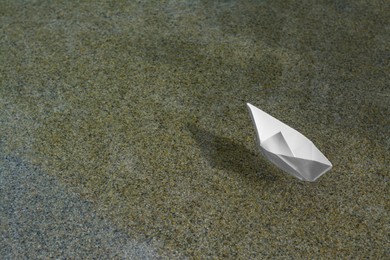 Beautiful white paper boat on water outdoors, space for text