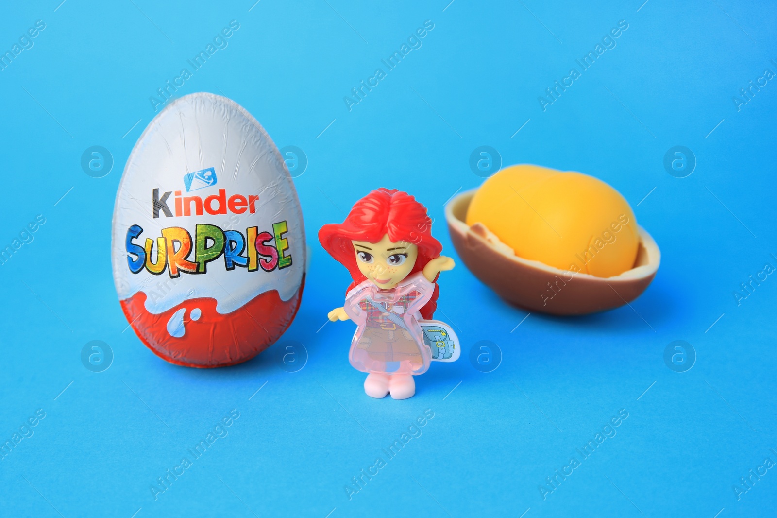 Photo of Slynchev Bryag, Bulgaria - May 25, 2023: Kinder Surprise Eggs, plastic capsule and toy on light blue background