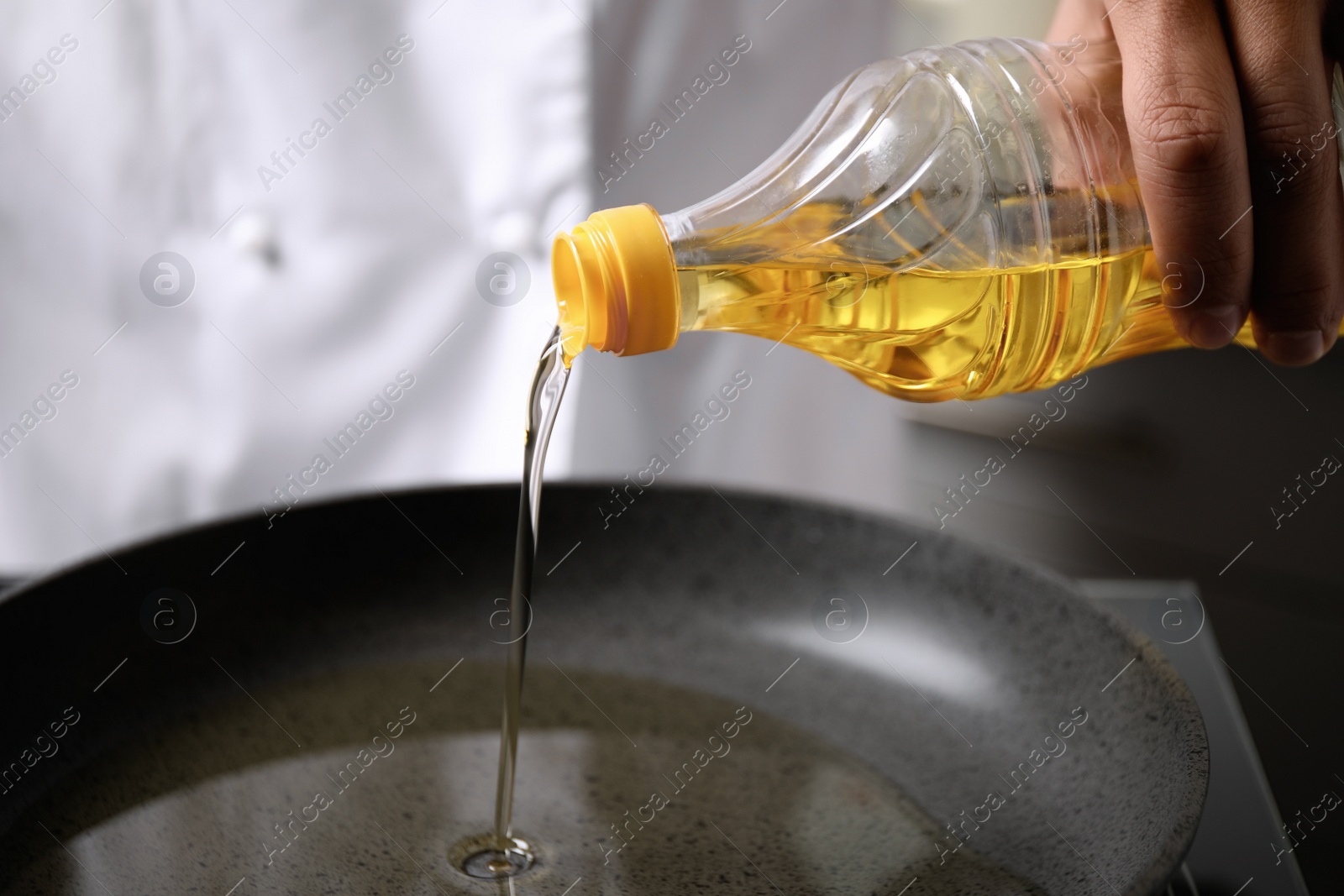 Photo of Man pouring cooking oil from bottle into frying pan, closeup