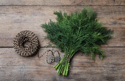 Fresh dill and twine on wooden table, flat lay