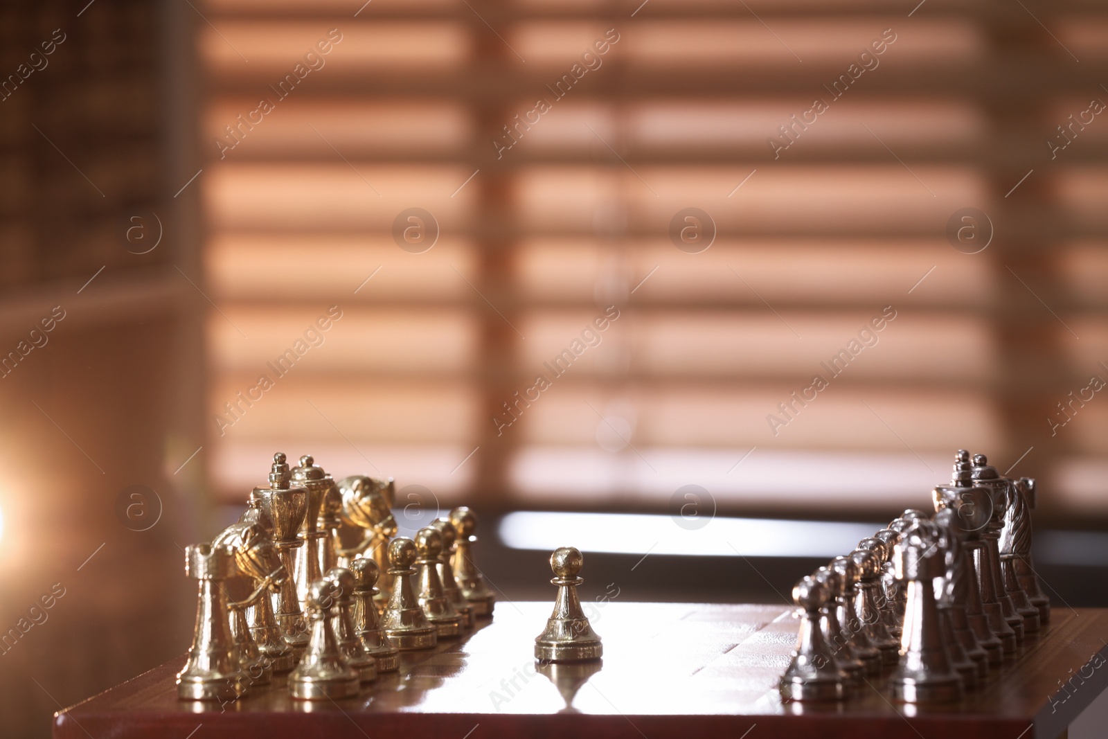 Photo of Chessboard with game pieces near window indoors, space for text