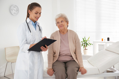 Doctor examining senior patient in modern office