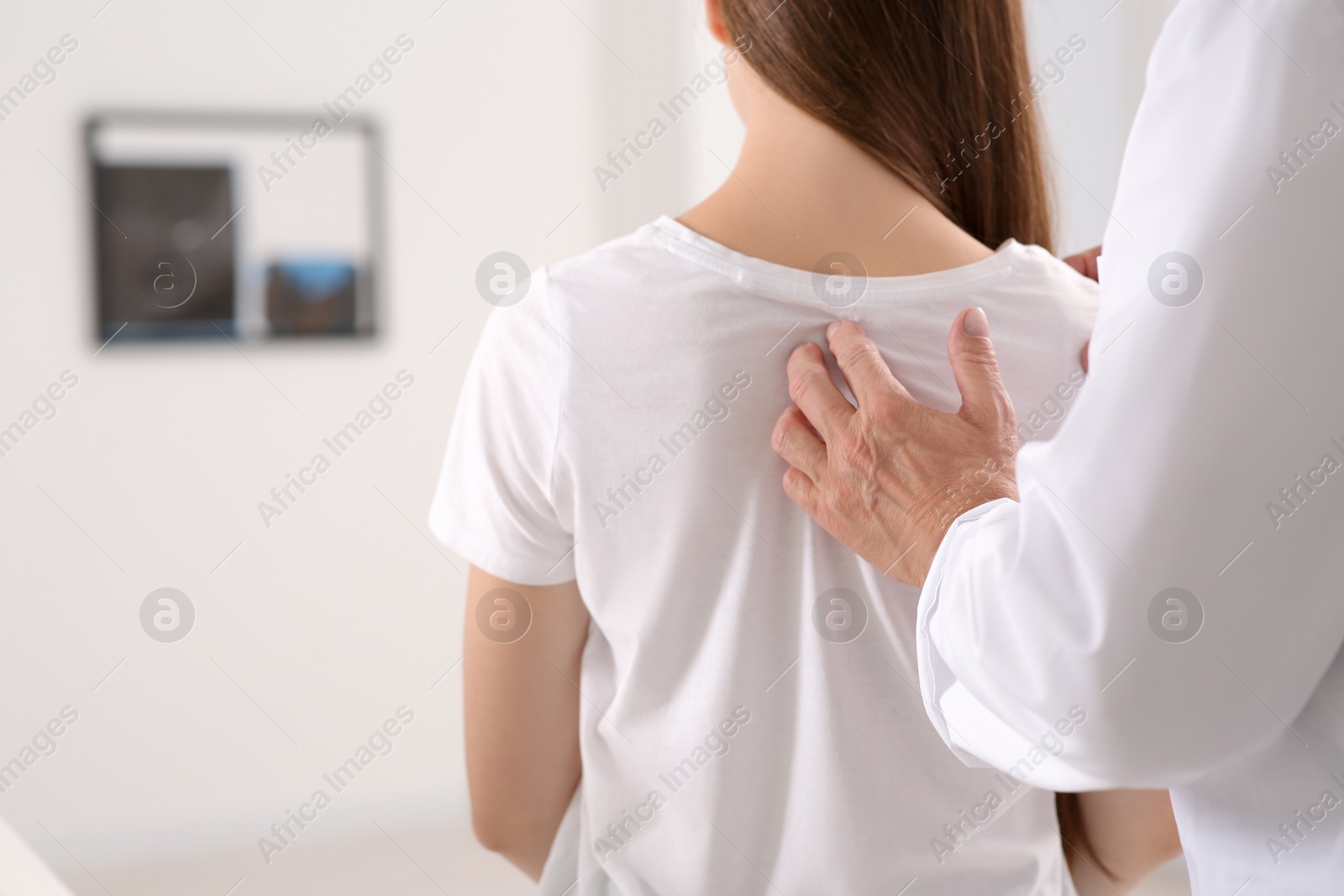 Photo of Professional orthopedist examining patient's neck in clinic, closeup