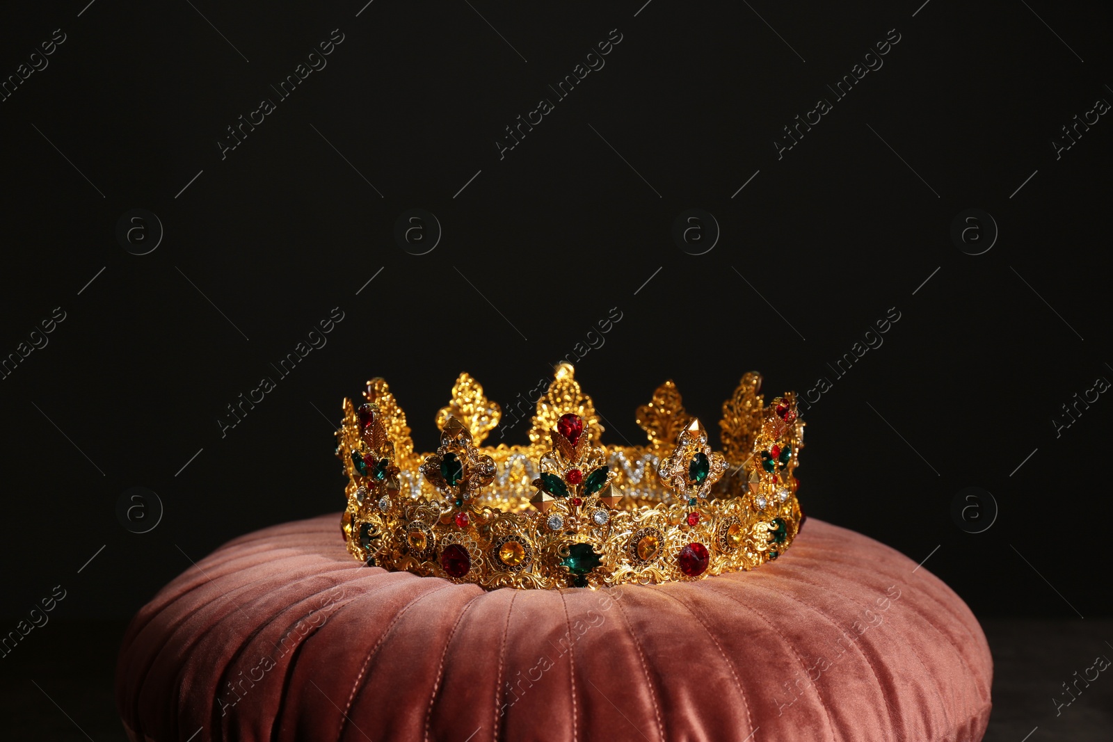 Photo of Beautiful golden crown on pink velvet pillow. Fantasy item