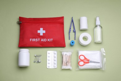 Photo of Flat lay composition with first aid kit on light green background