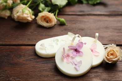 Photo of Scented sachets and flowers on wooden table