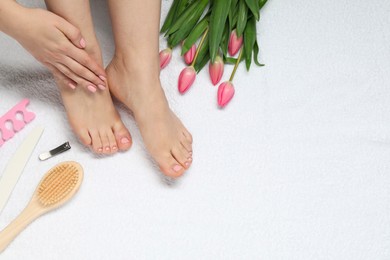 Closeup of woman with neat toenails after pedicure procedure on white terry towel, top view. Space for text