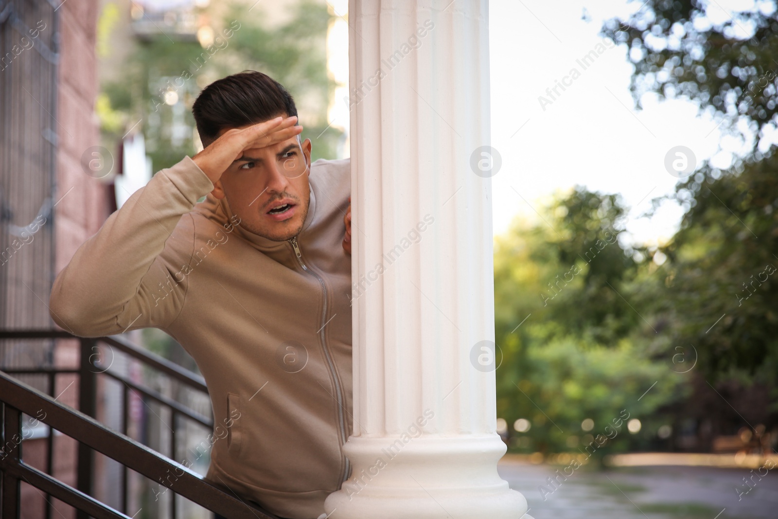 Photo of Jealous man spying on ex girlfriend outdoors