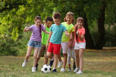 Photo of Cute little children playing with soccer ball in park