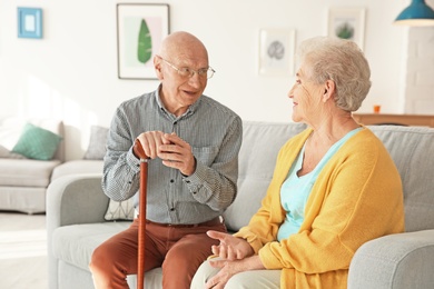 Photo of Elderly couple sitting on couch in living room