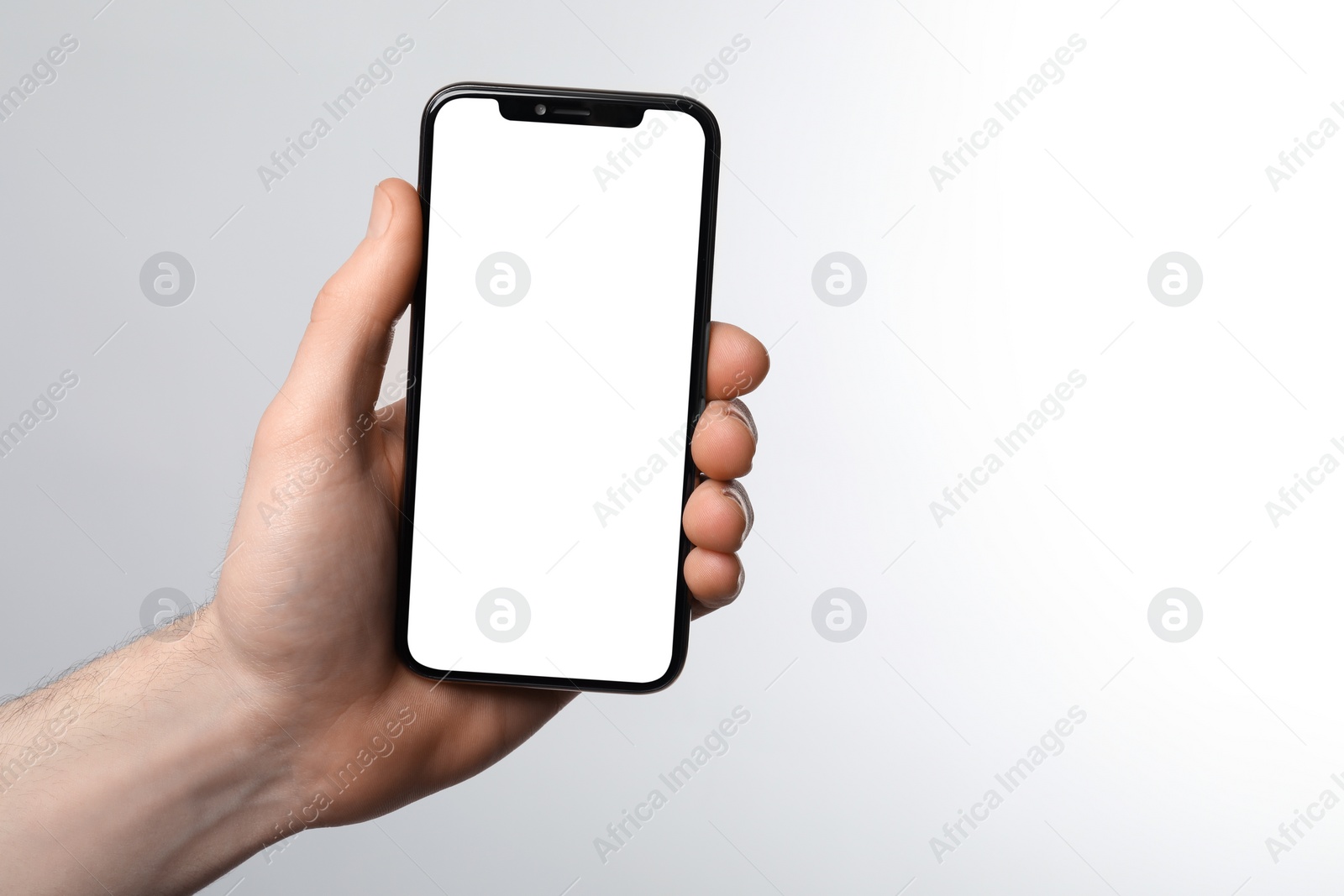 Photo of Man holding smartphone with blank screen on white background. Mockup for design