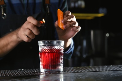 Photo of Barman making Red Russian cocktail at counter in pub, closeup. Space for text