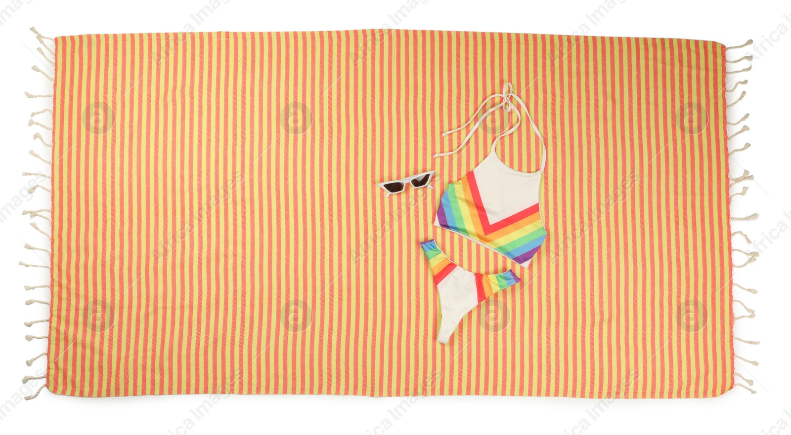 Photo of Striped beach towel with swimsuit and sunglasses on white background, top view