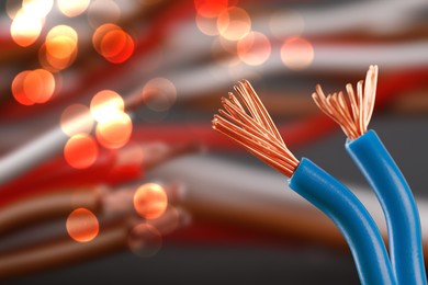 Image of Electrical wires against background with blurred lights, closeup. Space for text