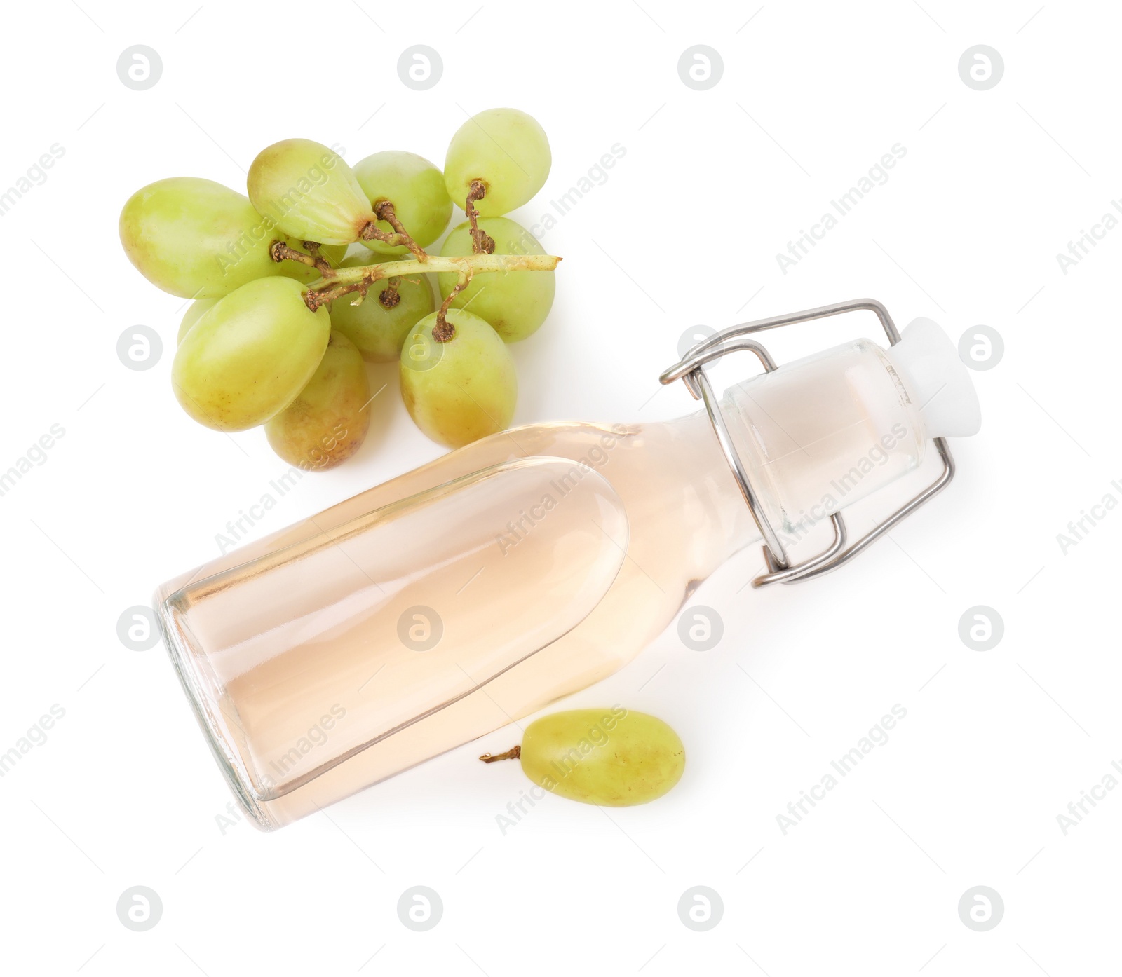 Photo of Grape vinegar in bottle and berries isolated on white, top view