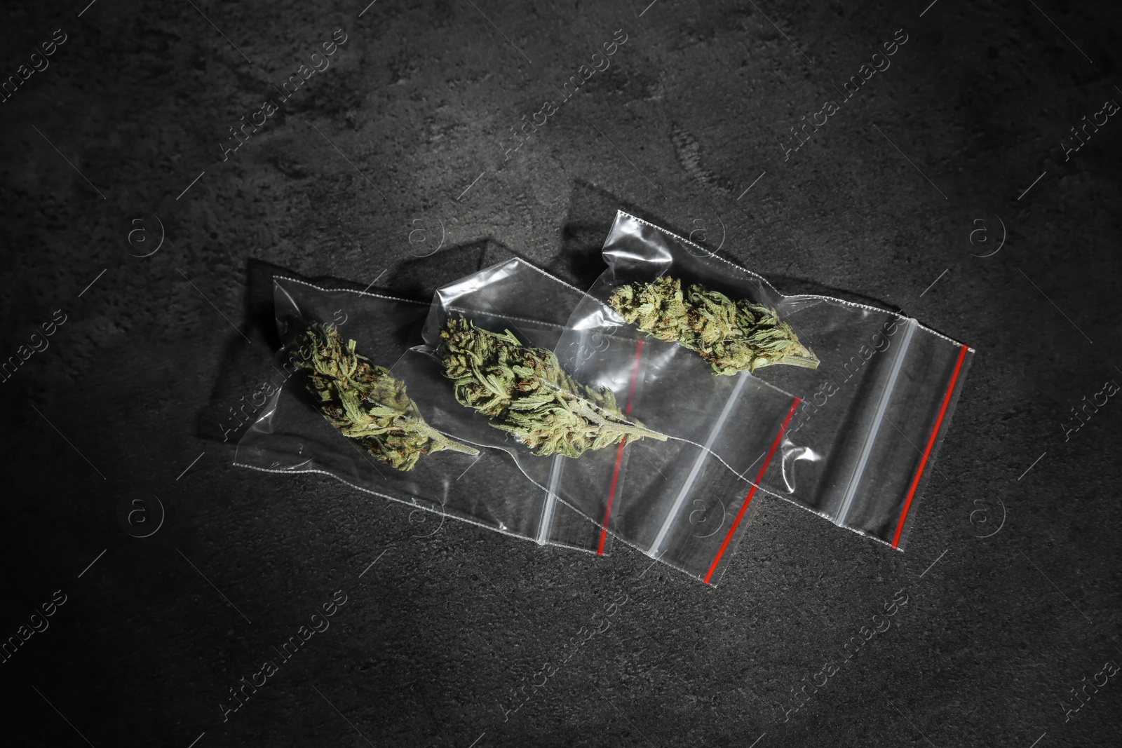 Photo of Dried hemp in plastic bags on grey background, top view