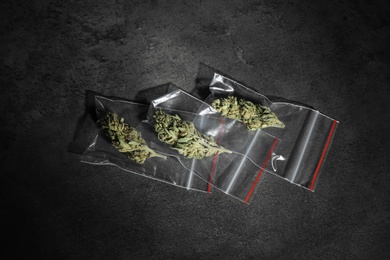 Photo of Dried hemp in plastic bags on grey background, top view