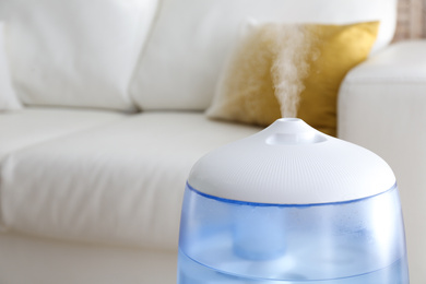 Photo of Modern air humidifier at home, closeup view. Space for text