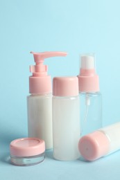 Photo of Cosmetic travel kit on light blue background. Bath accessories